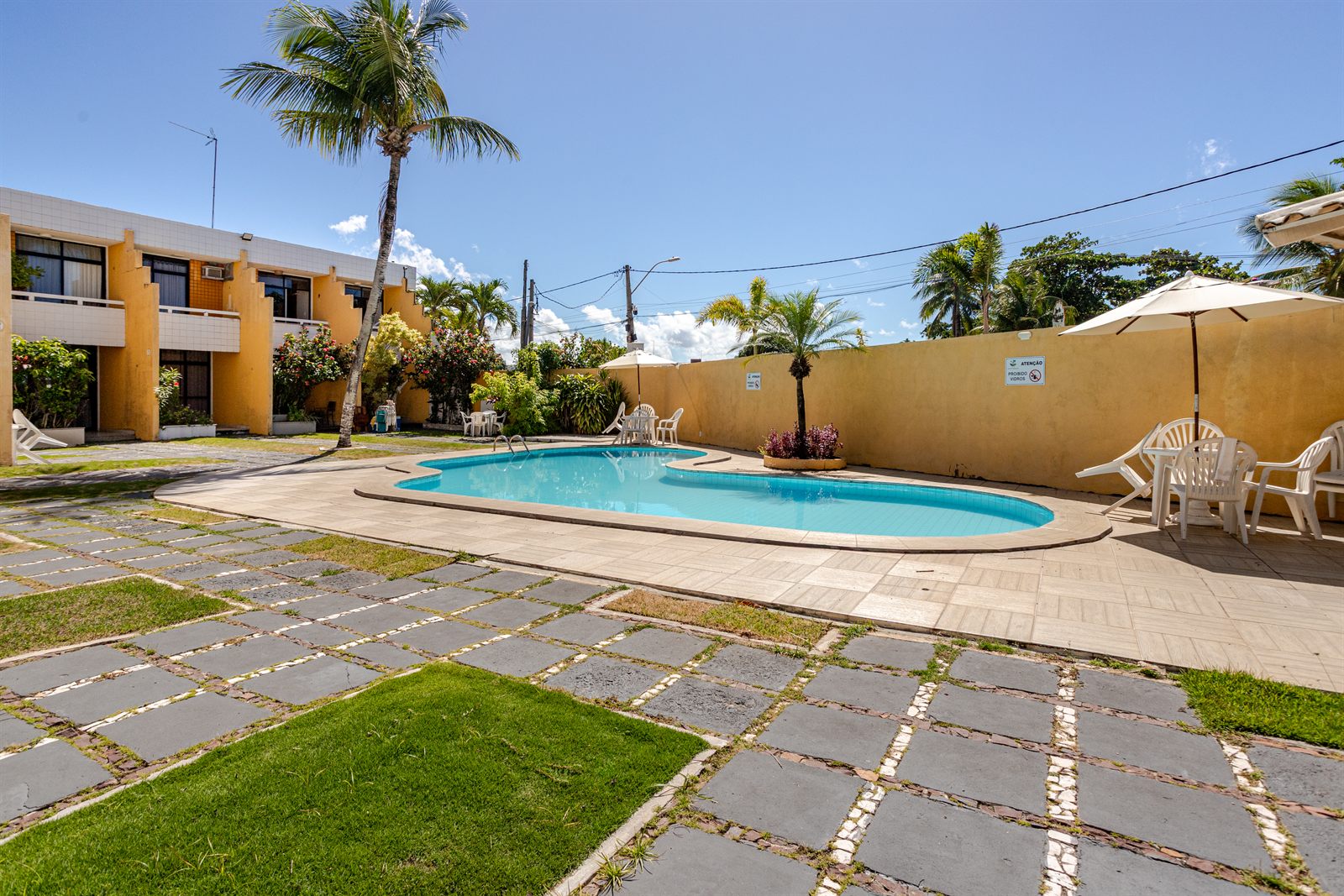 Piscina do condomínio entre coqueiros